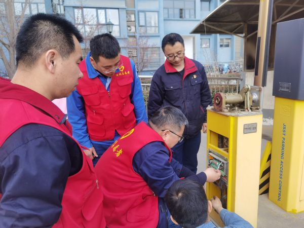 3月2日学雷锋活动现场，党员王虎强等人对小区停车场出入抬杠进行检查.jpg